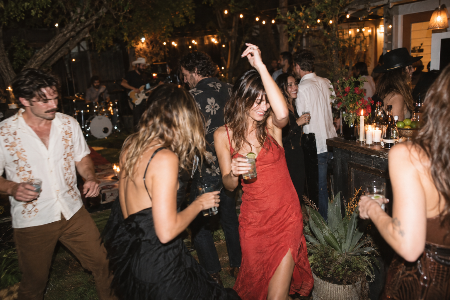 Candid flash photograph of a stylish backyard gathering at night